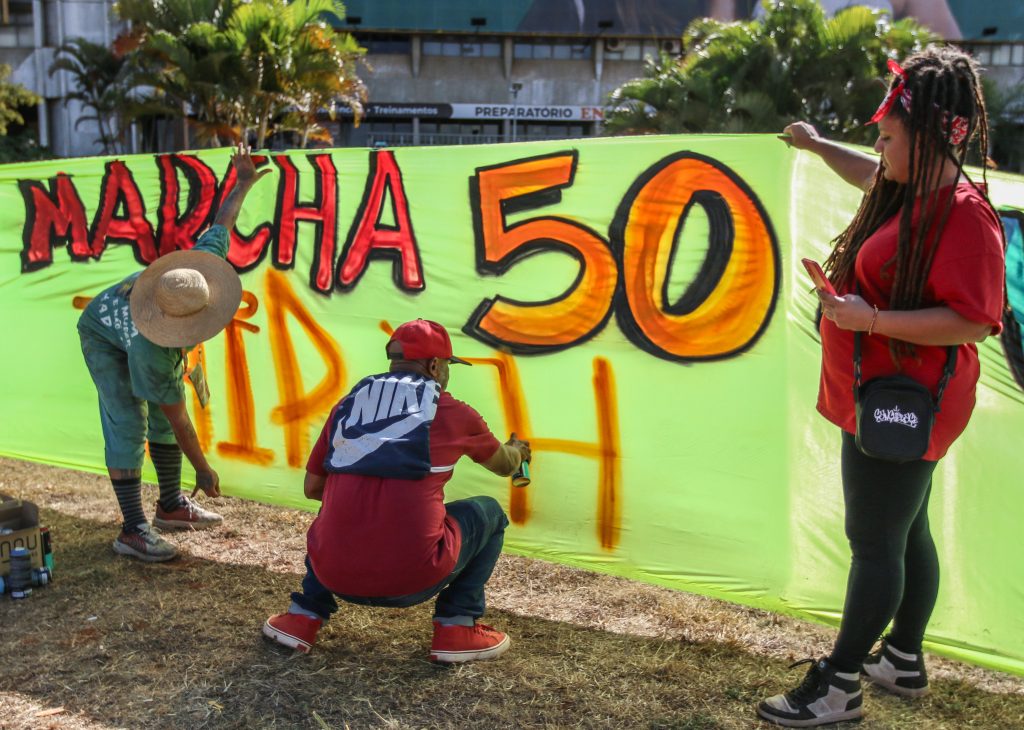 (Brasília/DF, 17/07/2023) – Vestindo vermelho, à direita, Lidiane Lima segura cartaz do movimento Hip Hop brasileiro, durante marcha da Cultura Hip Hop em celebração ao Cinquentenário mundial da Cultura Hip Hop. Foto: José Cruz/Agência Brasil