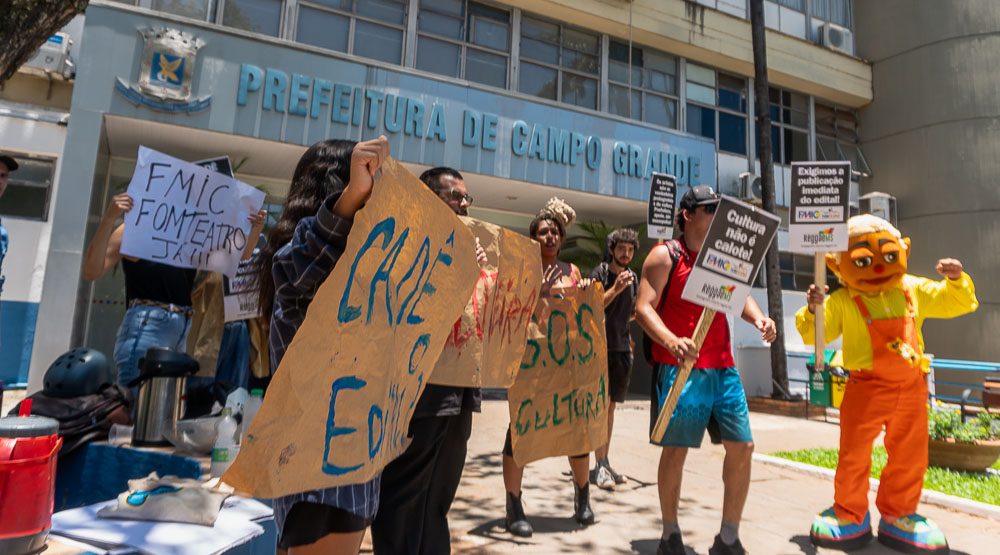 Manifestantes exibiram cartazes cobrando pagamento dos editas culturais caloteados pela prefeita de Campo Grande. Foto: Tero Queiroz