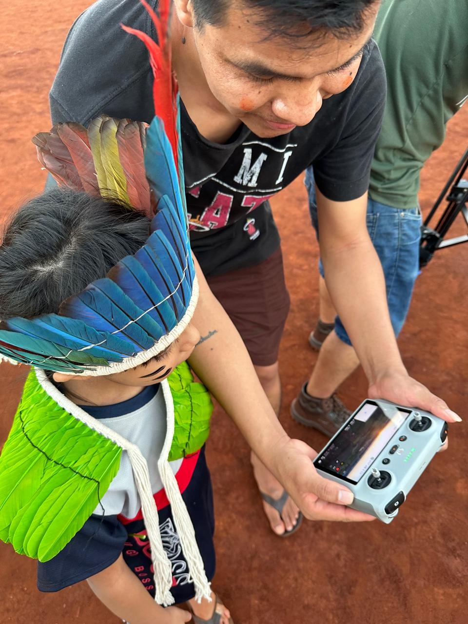 Luan Iturv mostra como funciona o drone a uma criança indígena. Foto: Marinete Pinheiro